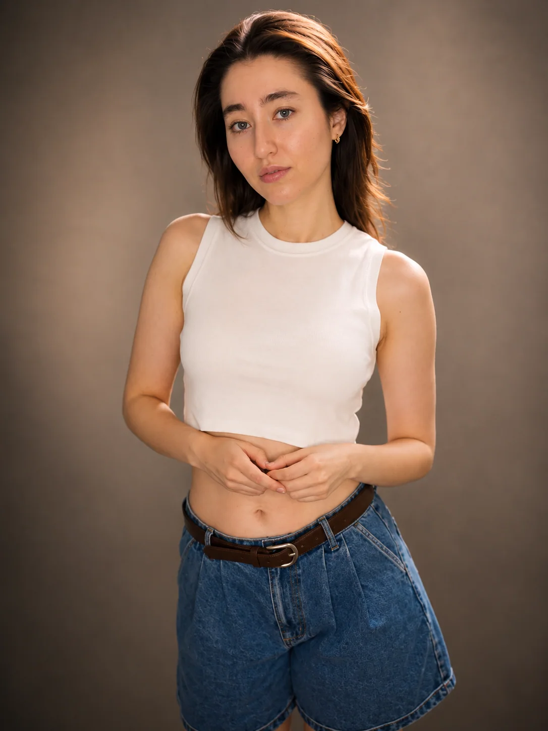 Natural studio portrait of Yaroslavna in a white sleeveless top and denim