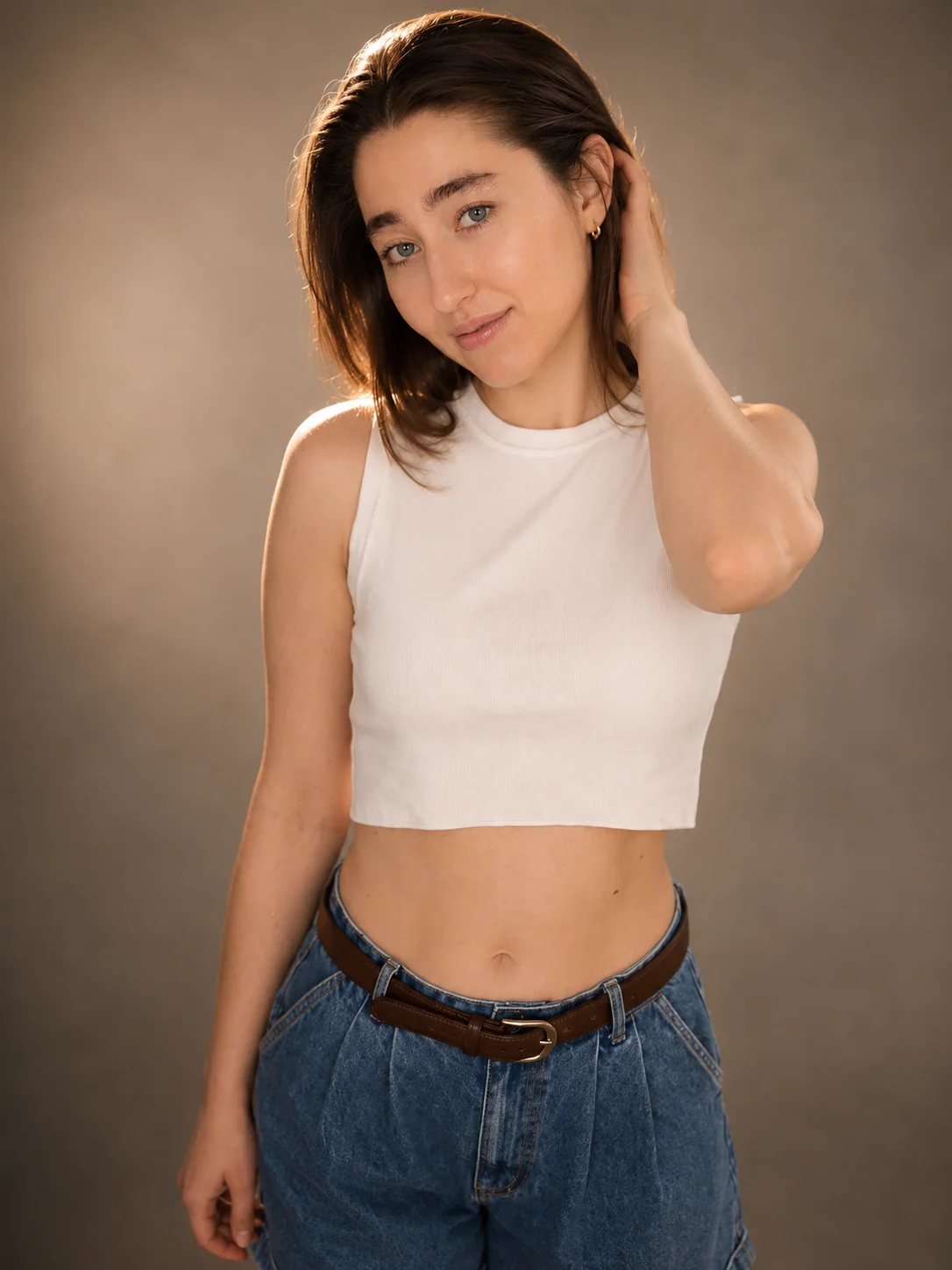 Yaroslavna in a white sleeveless top against a warm studio background